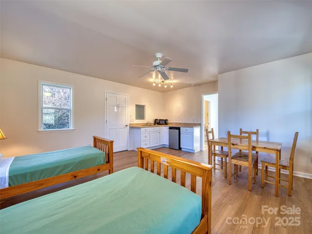 a living room with furniture and a dining table with kitchen view