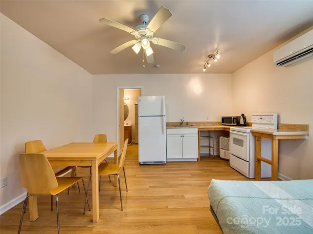 a kitchen with a table chairs refrigerator and microwave
