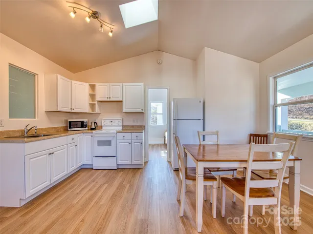 a large kitchen with cabinets wooden floor and stainless steel appliances