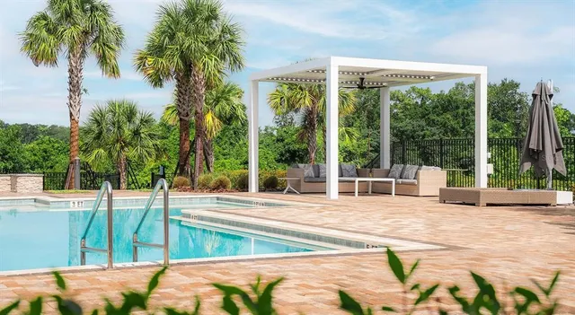 a large living room with kitchen island stainless steel appliances furniture a large window and a sink