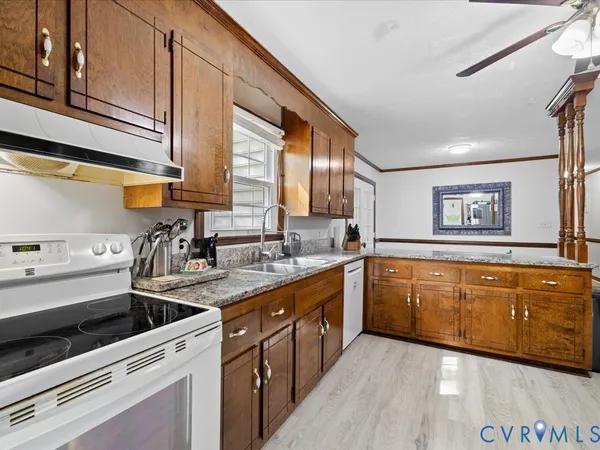 a kitchen with granite countertop a sink stainless steel appliances and cabinets