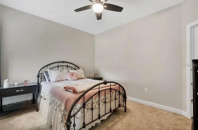 a bedroom with a bed a chandelier and a dresser