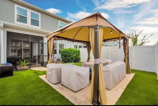 a view of backyard of house with seating area