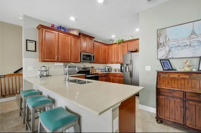 a kitchen with stainless steel appliances a stove a sink a microwave a refrigerator and cabinets