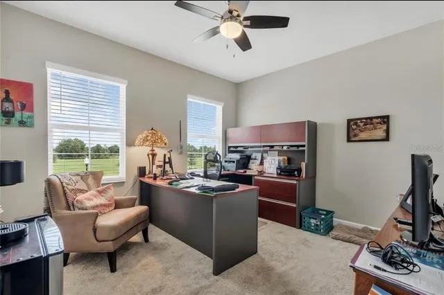 a view of a workspace with furniture and a window