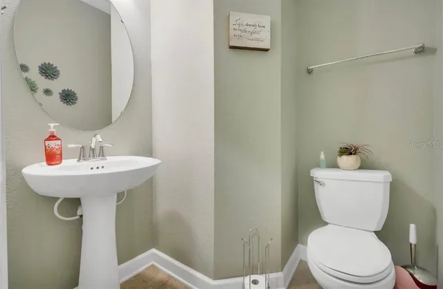 a bathroom with a toilet sink and mirror