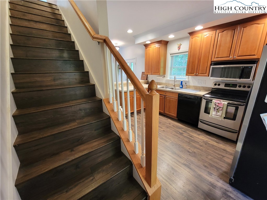 107 Stratford Lane, Unit 24B Boone, NC 28607 - Photo 22 of 45 a open kitchen with wooden floors and stainless steel appliances