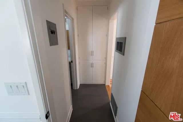 a view of a hallway with wooden floor and cabinets