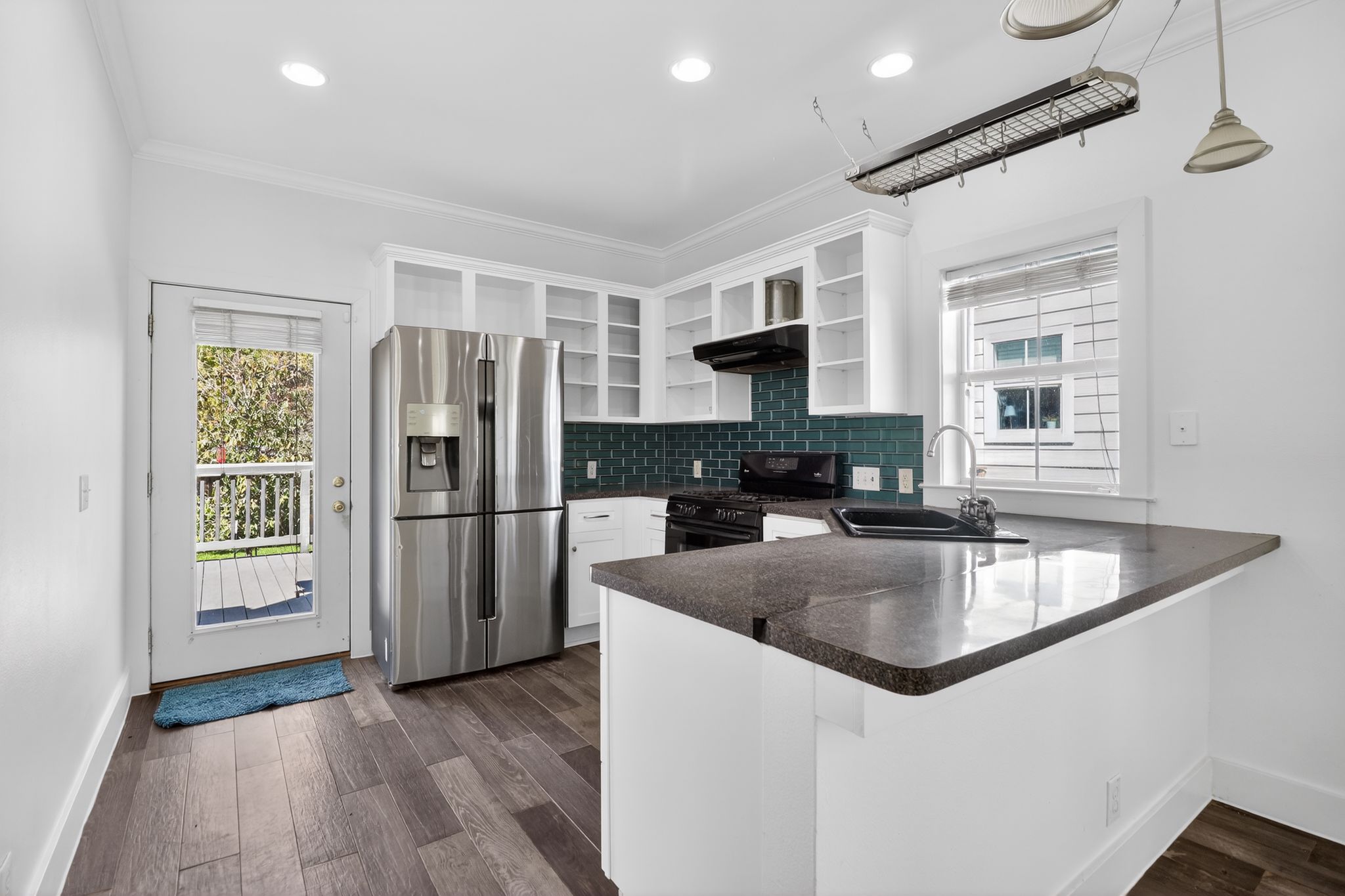 3614 South 2nd Street Austin, TX 78704 - Photo 13 of 40 a kitchen with stainless steel appliances granite countertop a refrigerator a sink a stove and a microwave oven with wooden floor