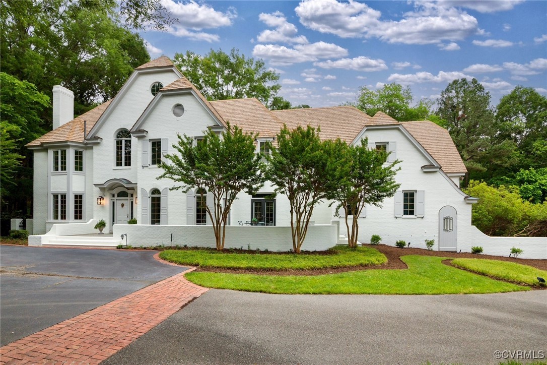 a front view of a house with a yard and trees