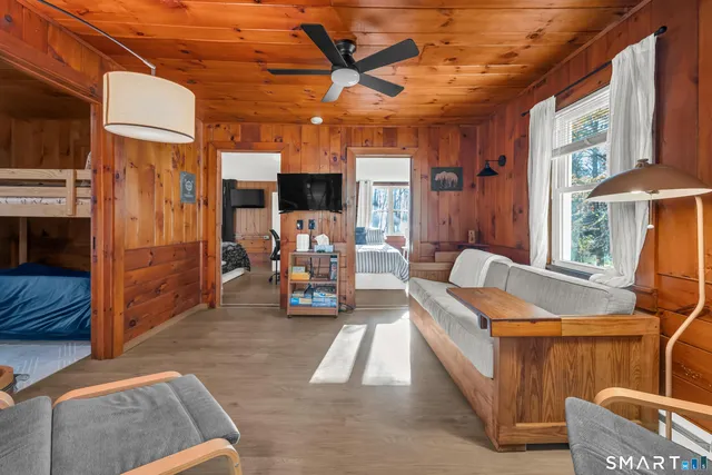 a living room with furniture a flat screen tv and a table