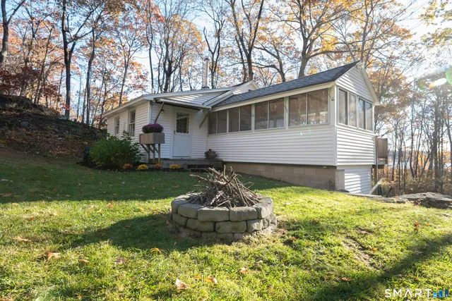 a front view of house with yard and trees in the background
