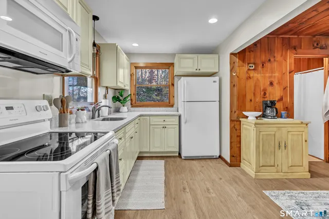 a kitchen with a sink a refrigerator a stove a washer dryer and cabinets