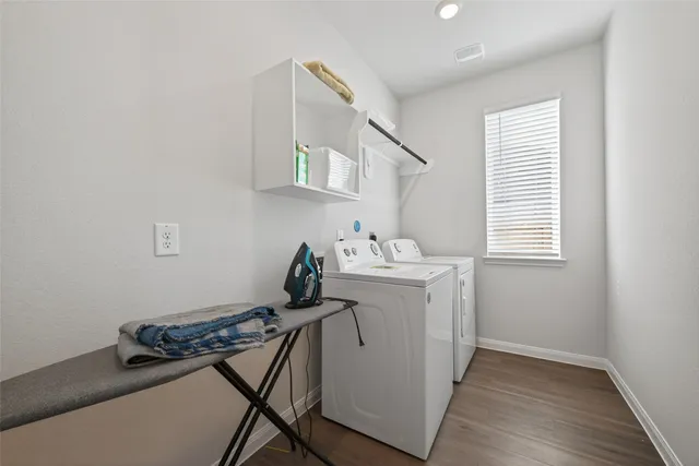 a utility room with cabinets washer and dryer