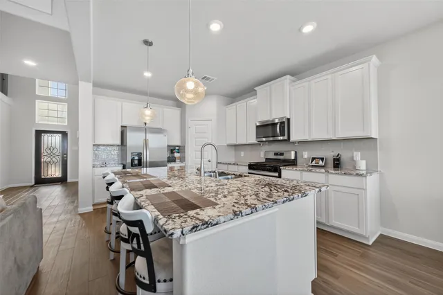 a kitchen with a table chairs microwave and cabinets