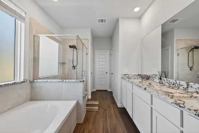 a bathroom with a tub sink and mirror