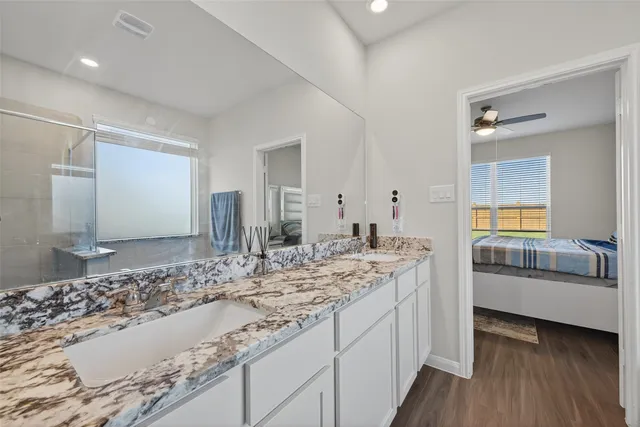 a bathroom with a granite countertop sink and a large mirror