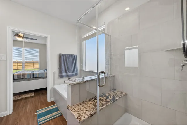 a bathroom with a granite countertop sink a mirror and shower