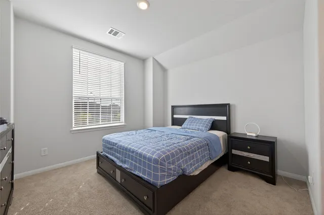 a bed sitting in a bedroom next to a window