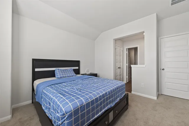 a bedroom with a bed and cabinet