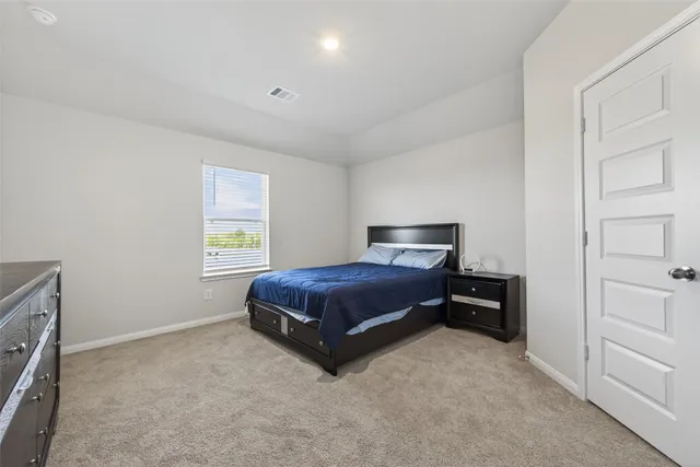 a spacious bedroom with a bed and a window