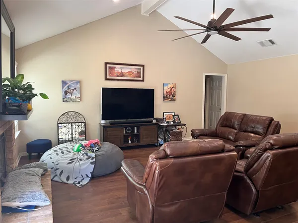 a living room with furniture a flat screen tv and a potted plant