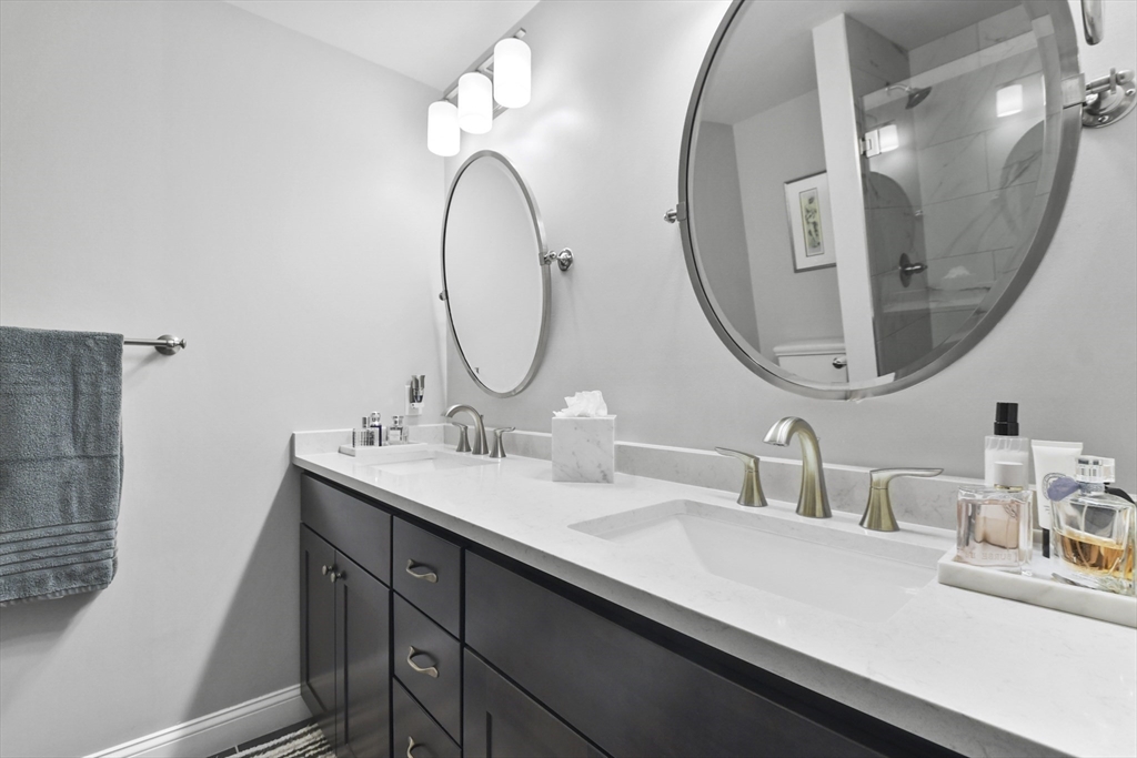 635 Old Post Road, Unit 108 Sharon, MA 02067 - Photo 30 of 42 a bathroom with a double vanity sink and a mirror