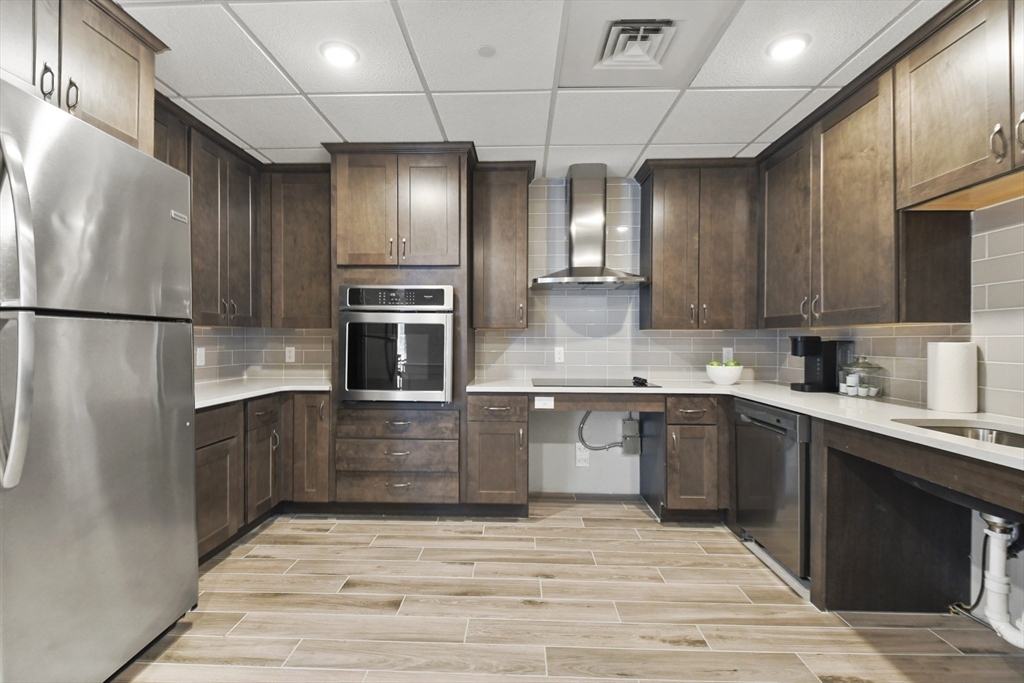 635 Old Post Road, Unit 108 Sharon, MA 02067 - Photo 39 of 42 a kitchen with stainless steel appliances granite countertop a refrigerator and a sink
