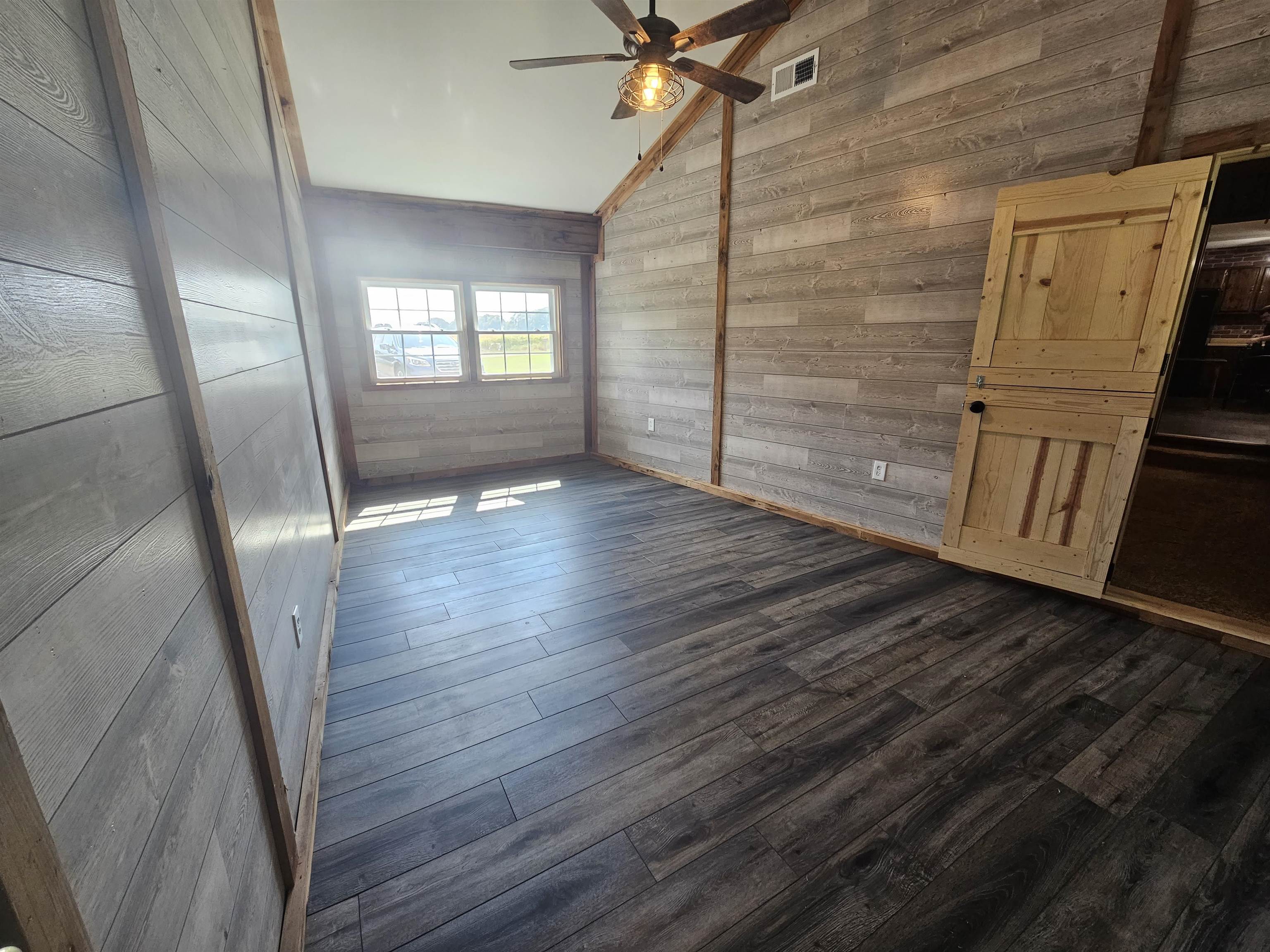 272 Brammer Road Covington, TN 38019 - Photo 11 of 31 a view of an empty room with wooden floor and a window