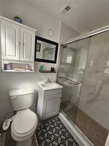 a white toilet sitting next to a bathroom sink