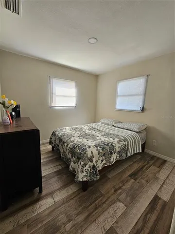 a bedroom with a bed and wooden floor