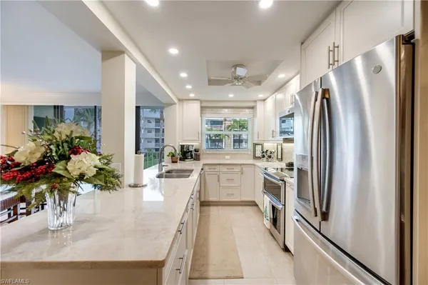 a kitchen with granite countertop a sink stainless steel appliances and cabinets