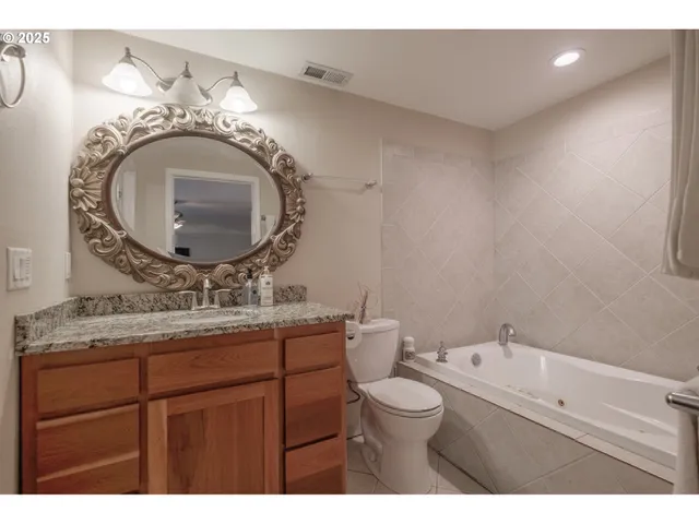 a bathroom with a granite countertop toilet a sink and mirror