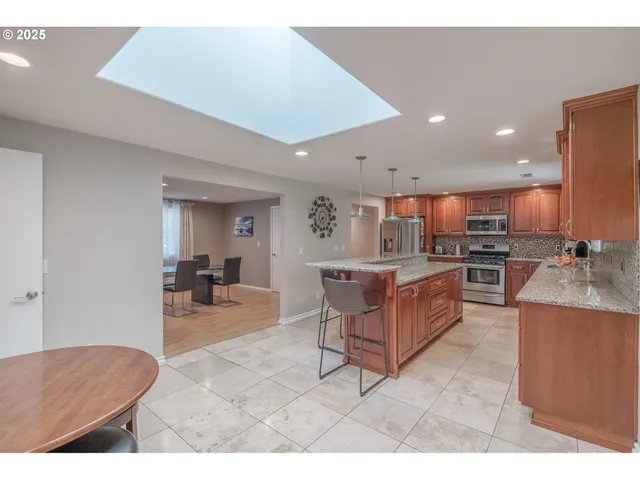 a living room with stainless steel appliances kitchen island granite countertop furniture and a view of kitchen