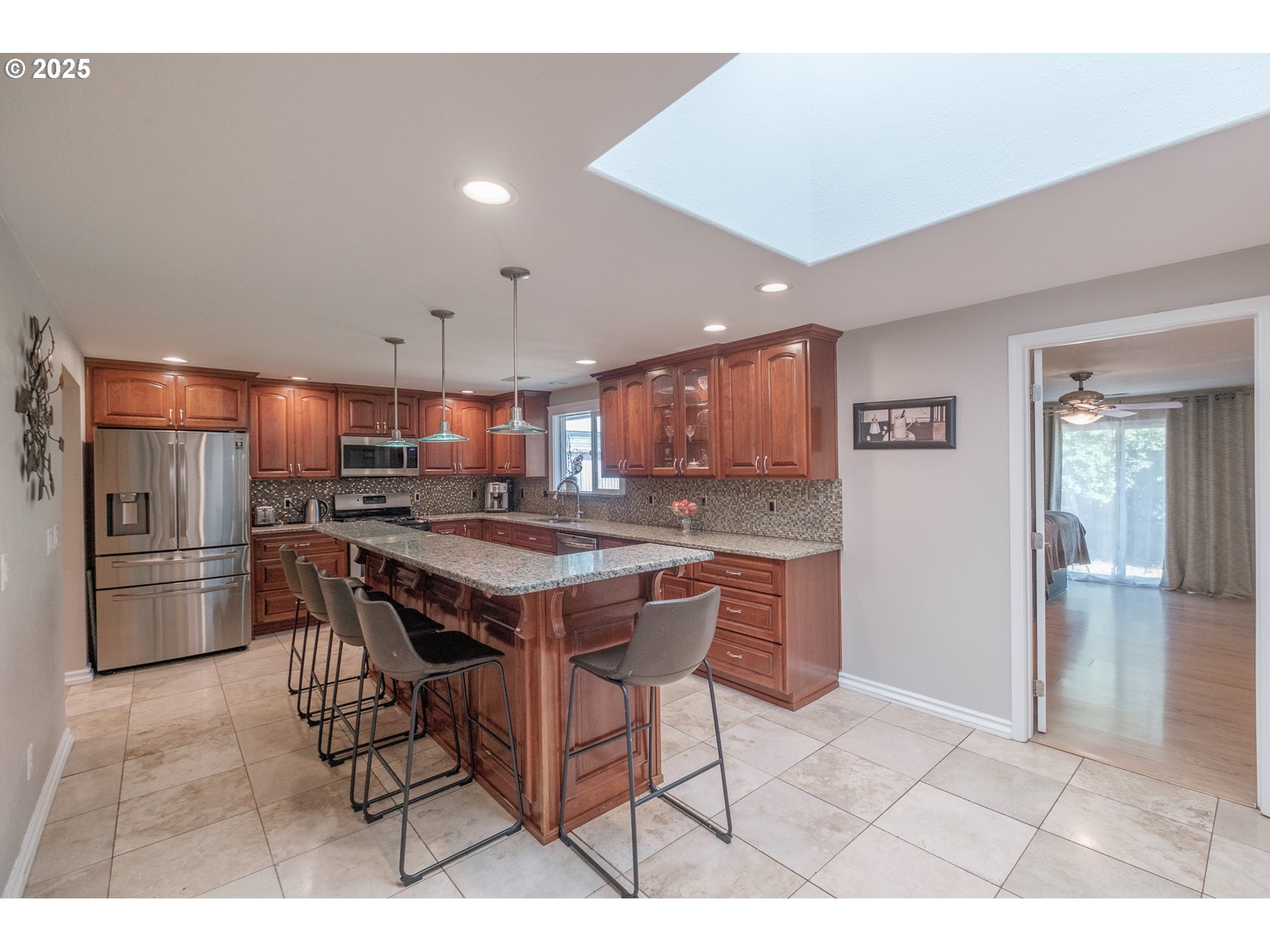 2225 Molalla Road Woodburn, OR 97071 - Photo 33 of 48 a kitchen with stainless steel appliances kitchen island granite countertop a table chairs sink and refrigerator