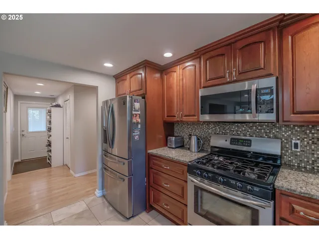 a kitchen with stainless steel appliances granite countertop a stove microwave and refrigerator