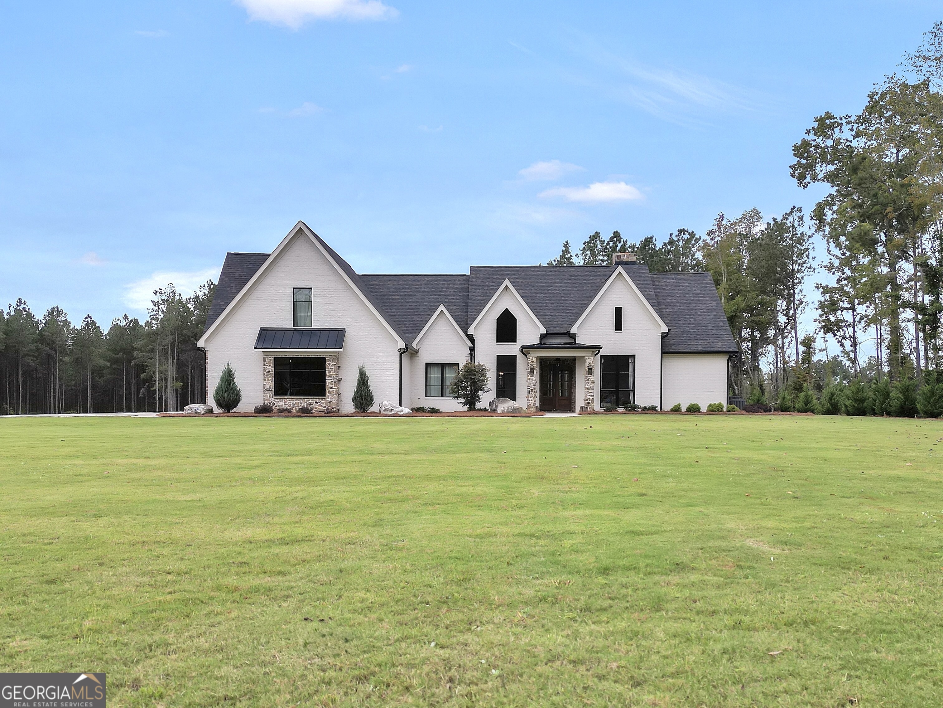a front view of a house with a yard and trees
