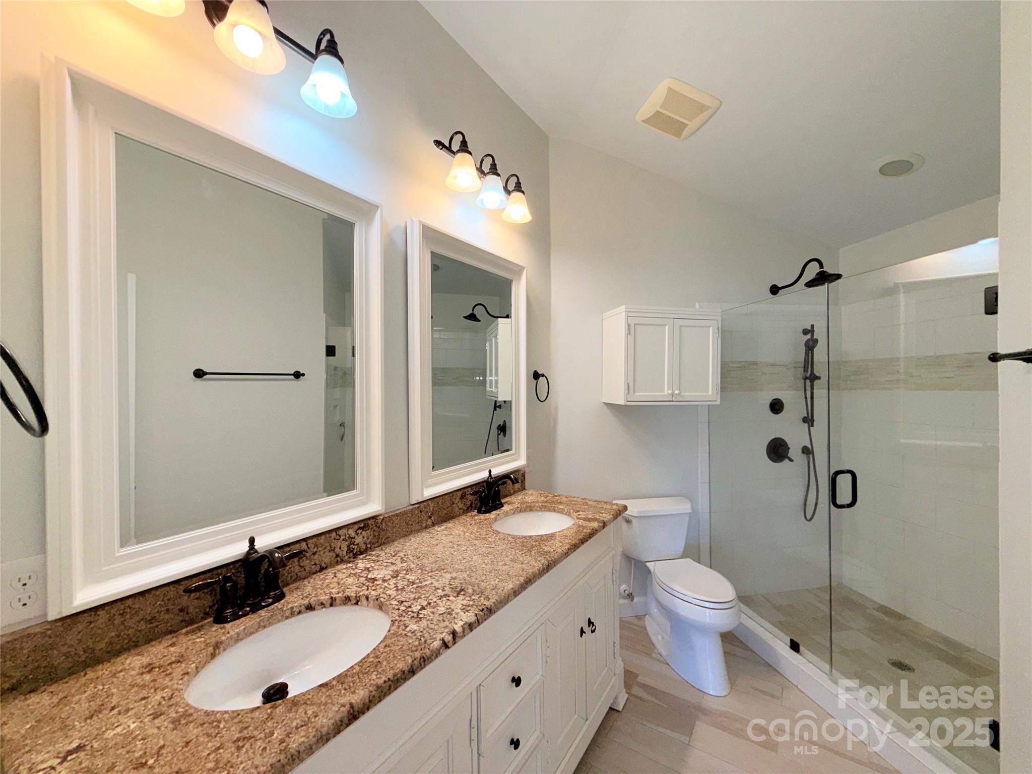 1133 Torrence Circle Davidson, NC 28036 - Photo 14 of 43 a bathroom with a granite countertop sink toilet mirror and shower