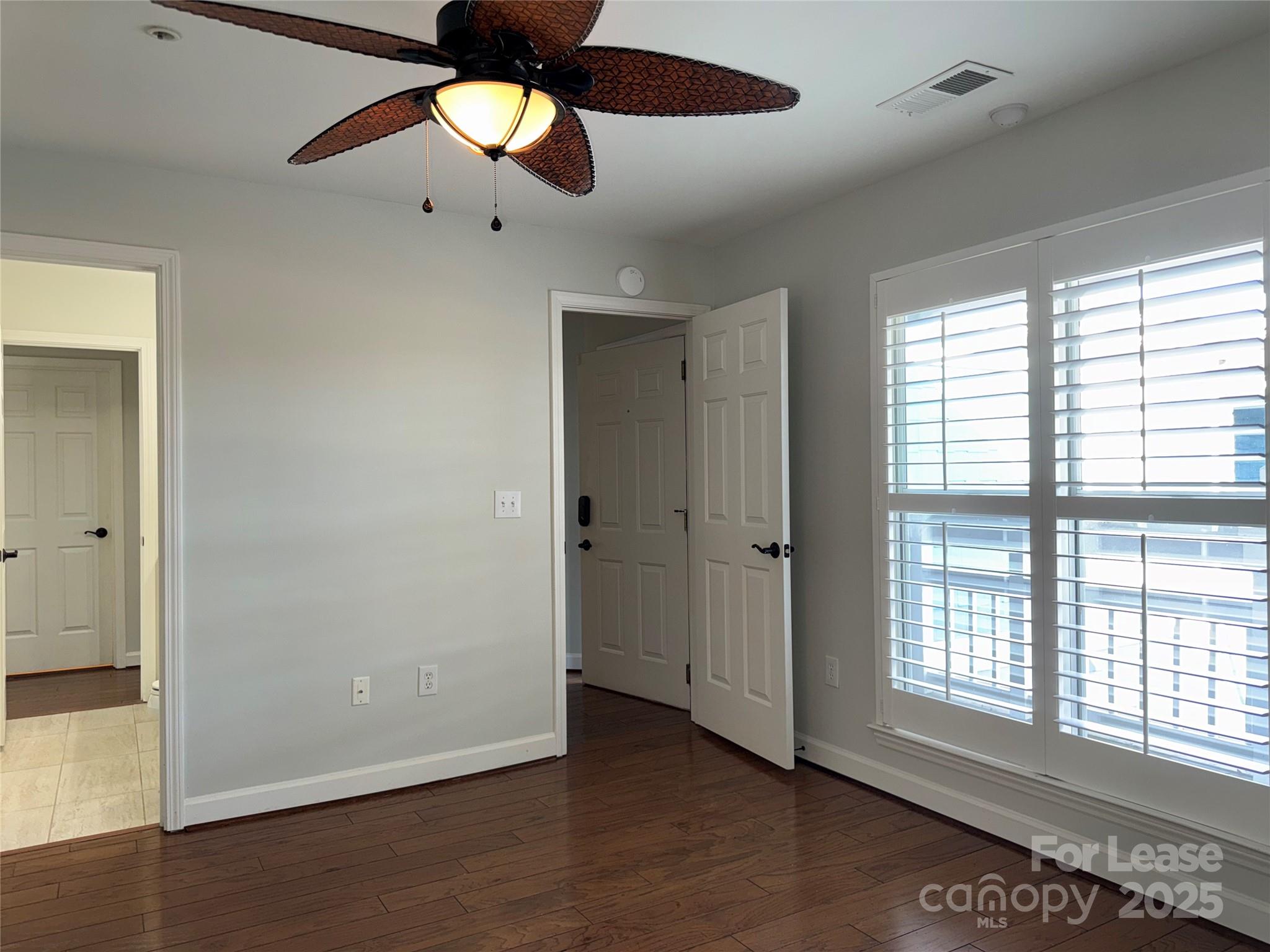 1133 Torrence Circle Davidson, NC 28036 - Photo 17 of 43 a view of an empty room with wooden floor and a window