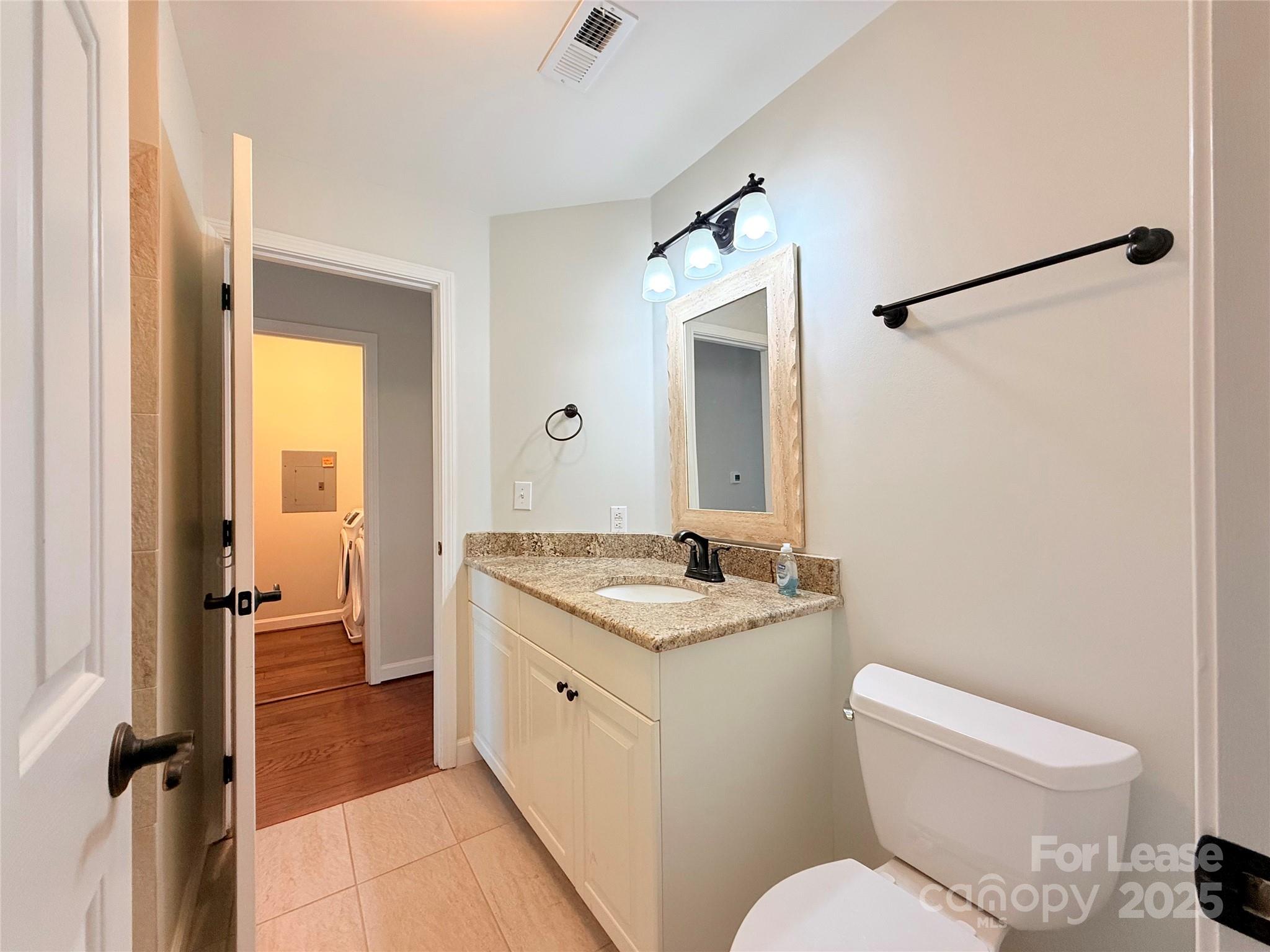 1133 Torrence Circle Davidson, NC 28036 - Photo 20 of 43 a bathroom with a granite countertop toilet sink and mirror