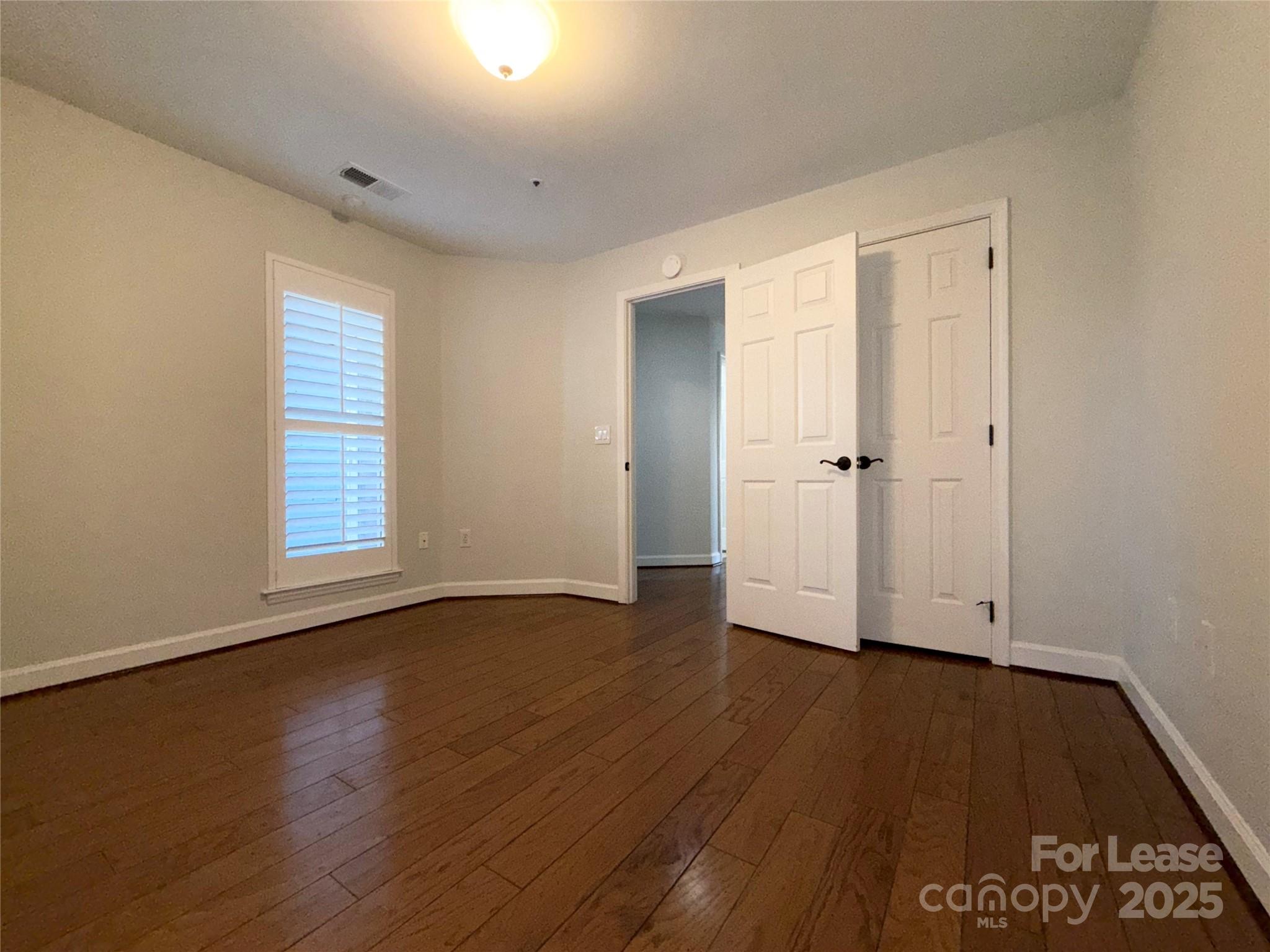 1133 Torrence Circle Davidson, NC 28036 - Photo 24 of 43 an empty room with wooden floor and windows