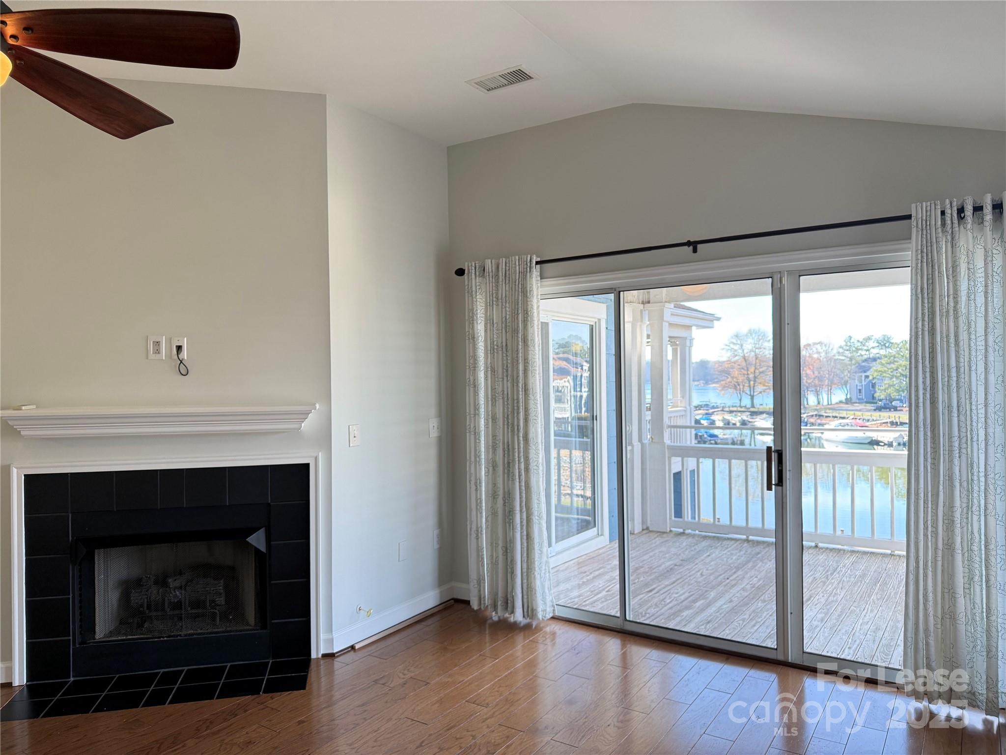 1133 Torrence Circle Davidson, NC 28036 - Photo 28 of 43 a living room with a fireplace and a floor to ceiling window