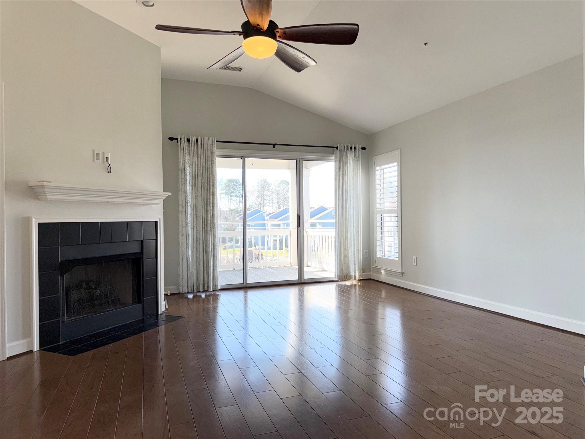 1133 Torrence Circle Davidson, NC 28036 - Photo 6 of 43 a view of an empty room with wooden floor fireplace and a window