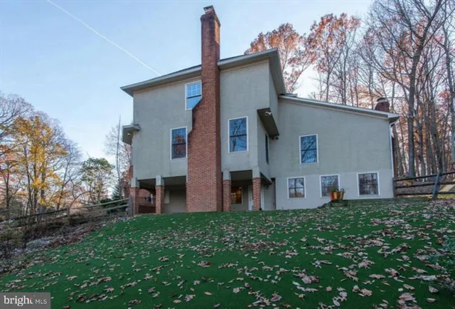 a front view of house with yard and trees in the background