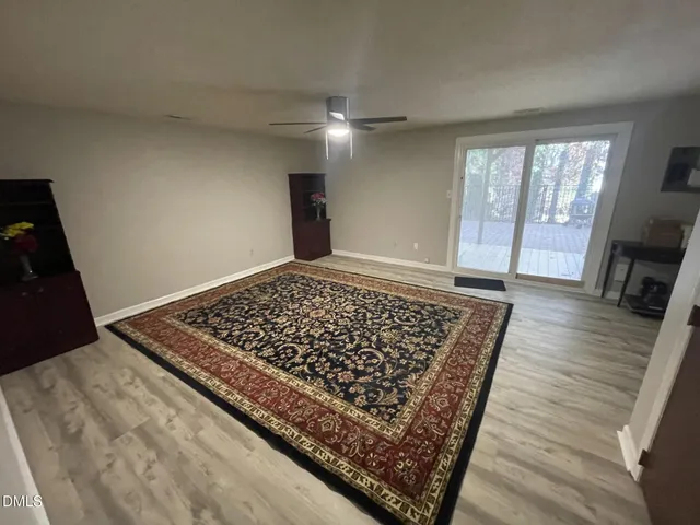 wooden floor in an empty room with a rug
