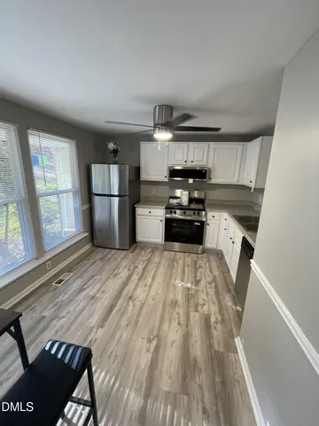 a kitchen with a sink a refrigerator and wooden floor