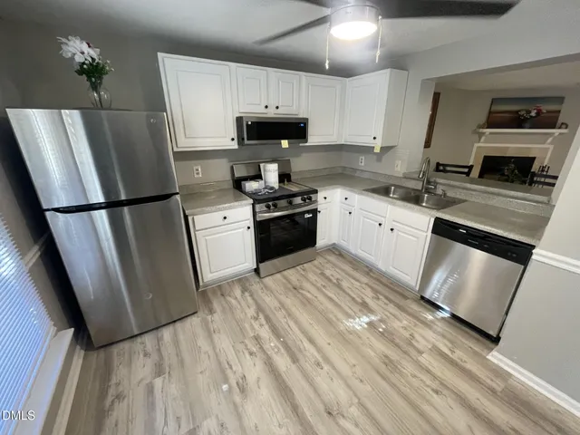 a kitchen with a refrigerator a stove top oven a sink and dishwasher