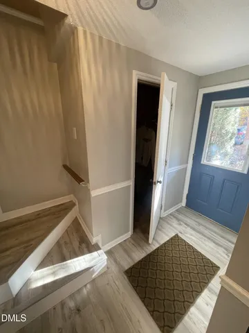 a view of a hallway with wooden floor and staircase