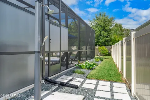 a view of a patio with table and chairs potted plants with floor to ceiling window