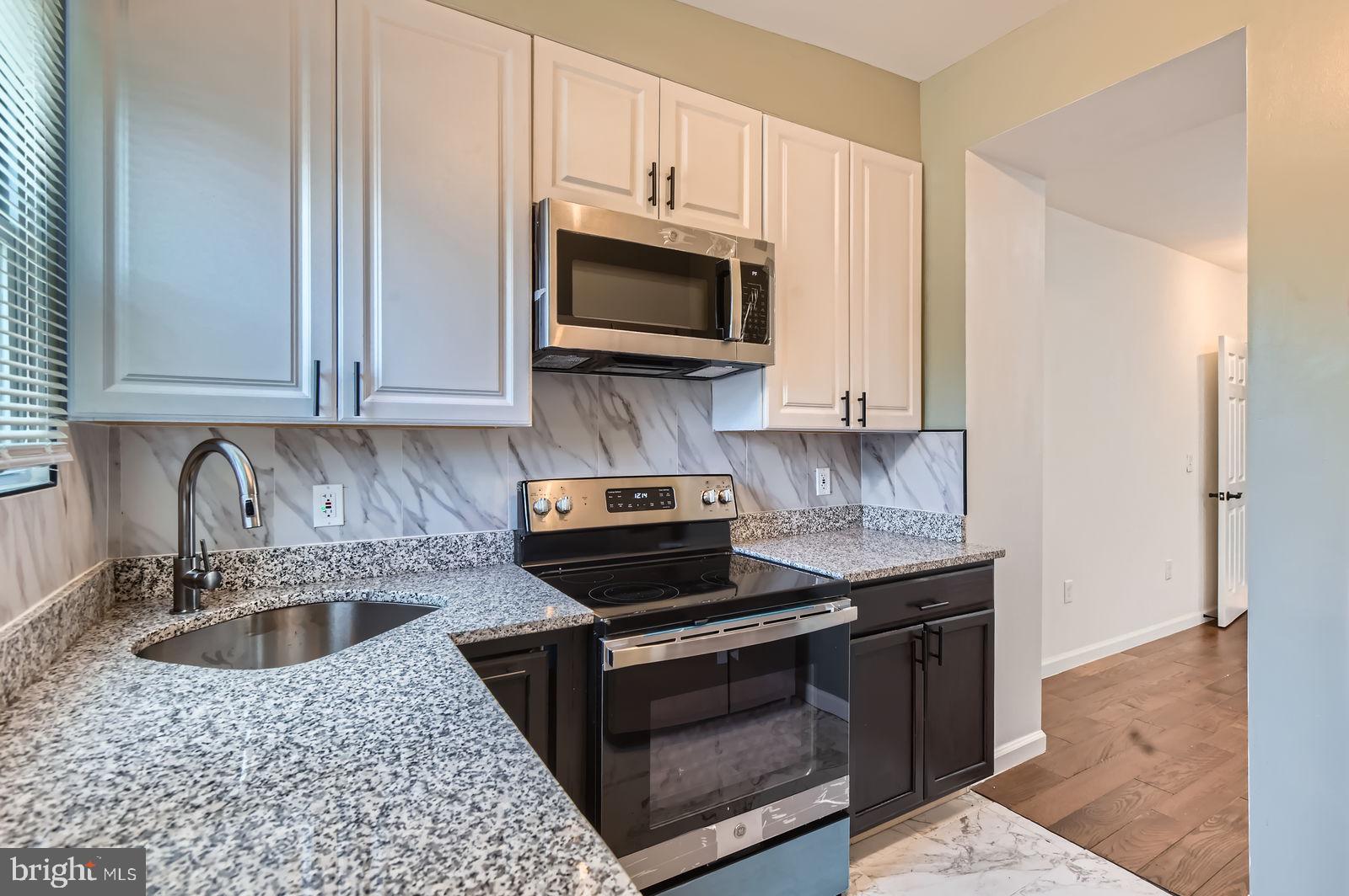 3617 Manchester Avenue Baltimore, MD 21215 - Photo 13 of 28 a kitchen with stainless steel appliances granite countertop a sink stove and microwave